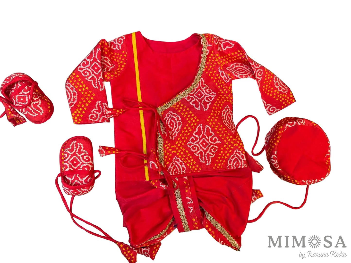 Red baby outfit with white patterns on a dark surface