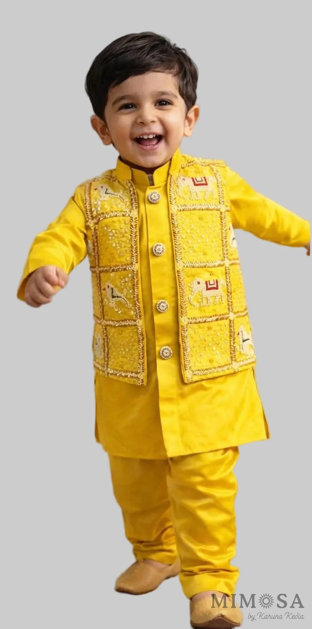 Child wearing a yellow traditional outfit with a textured vest on a neutral background