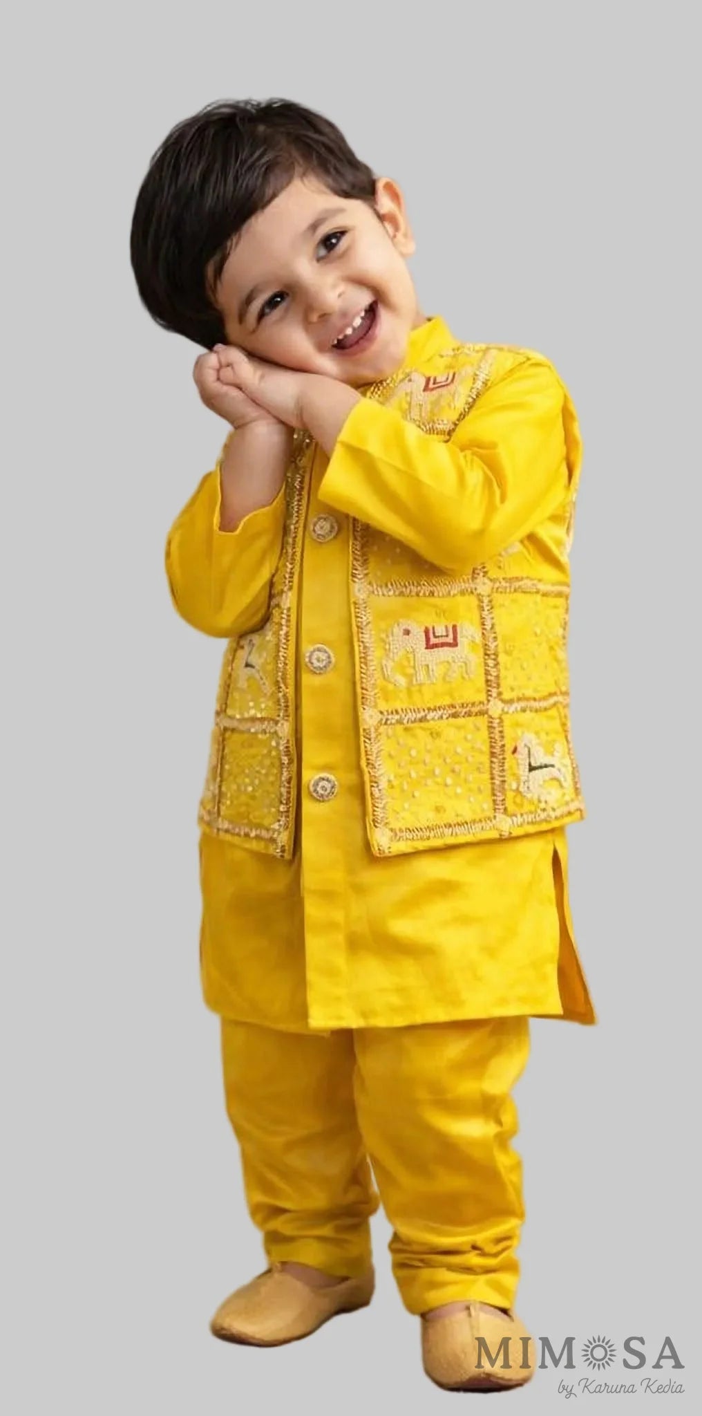 Child wearing a yellow traditional outfit with a textured background